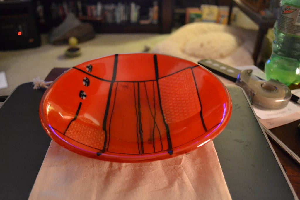 A finished fused glass bowl with layered colored glass