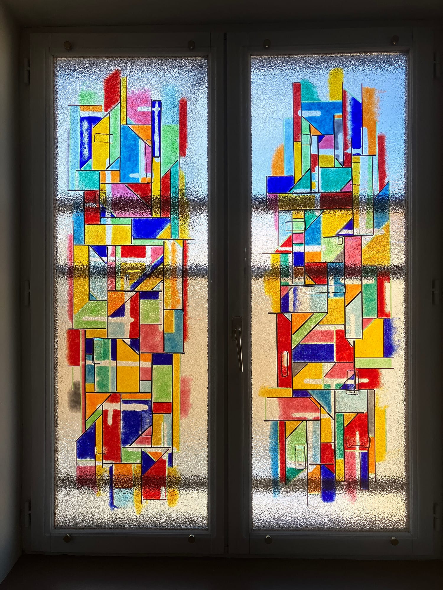 A vivid kiln-formed glass artwork with layered colors fused into a single panel