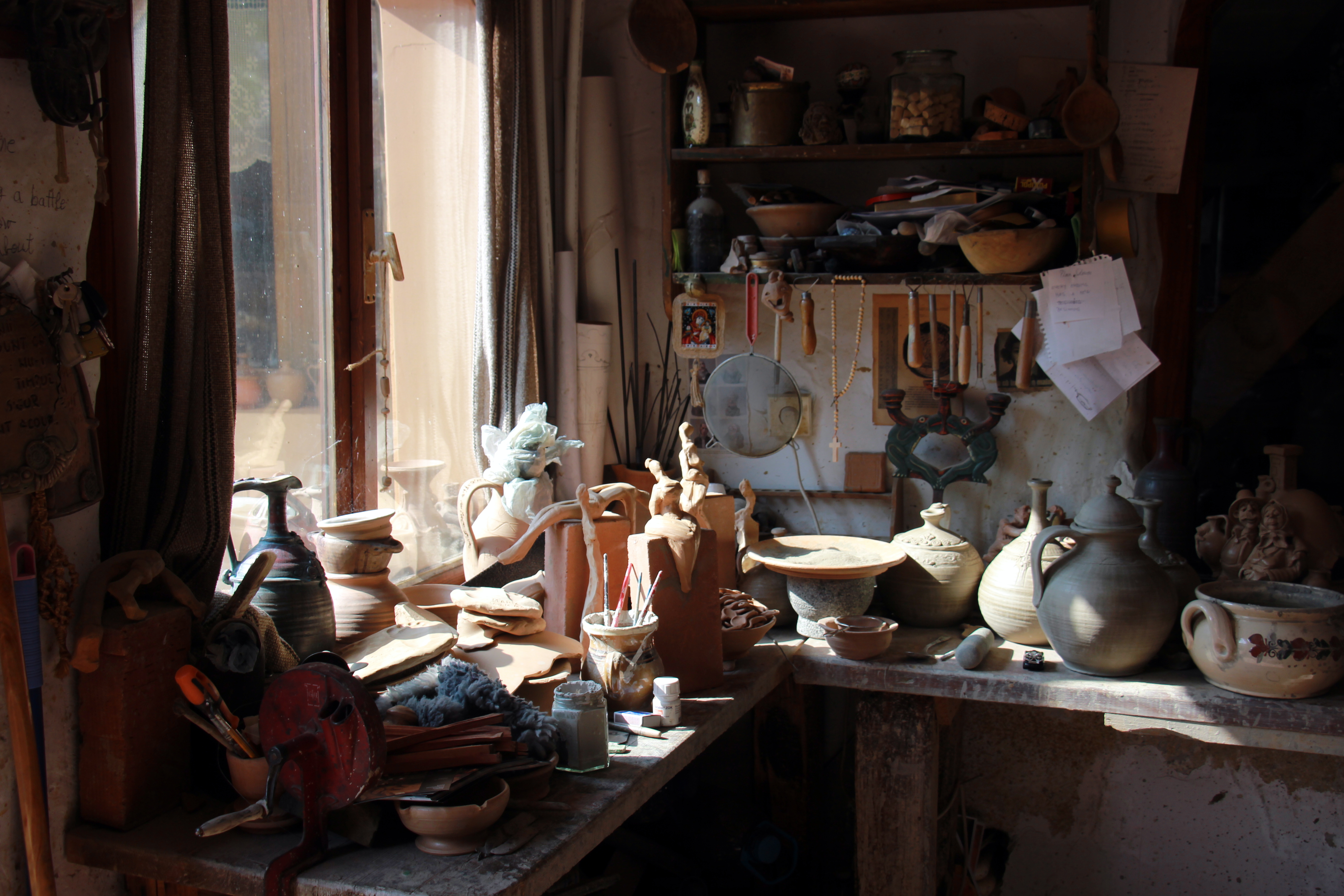 Ceramics workshop interior showing studio setup with kiln and ware boards for pottery production