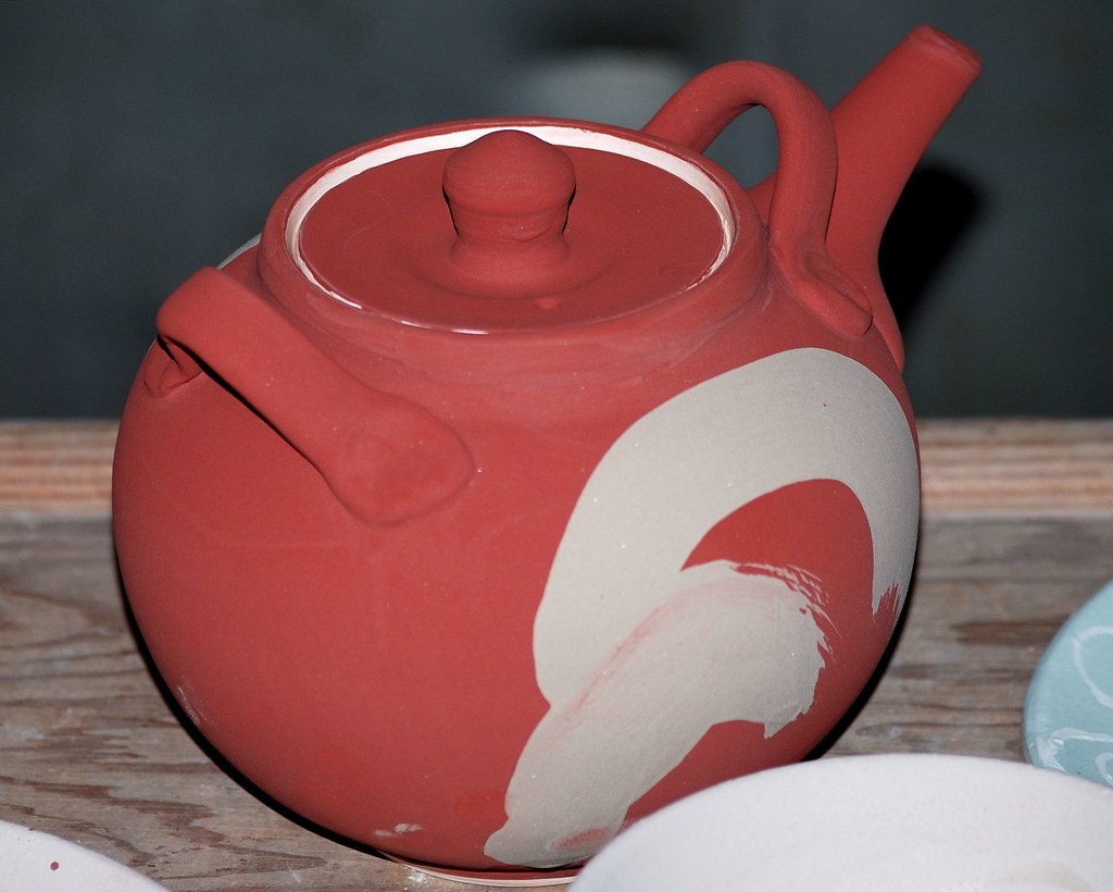 Small ceramic teapot and ceramic vessels representing the output of a controlled kiln firing