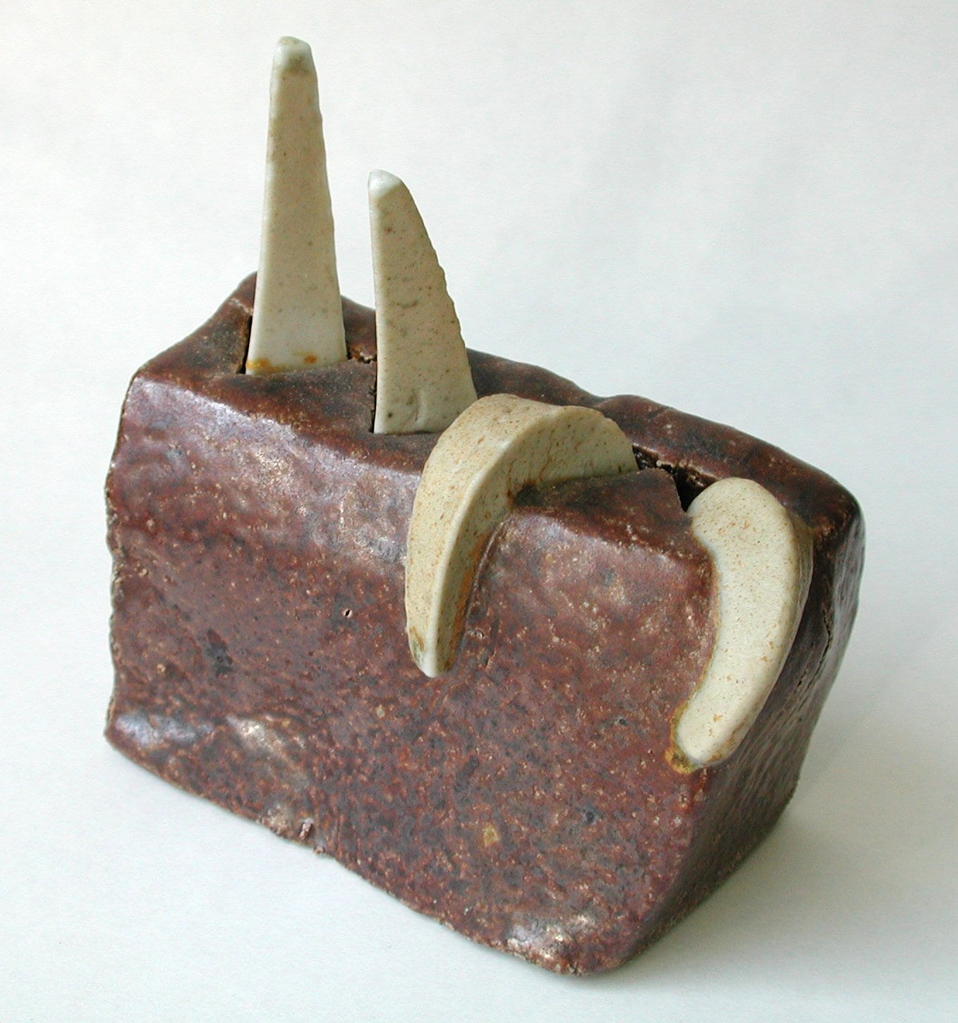 Three pyrometric cones bent to different angles after firing