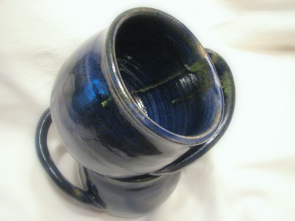 Row of colorful glazed ceramic mugs showing different cone-6 glaze results after firing