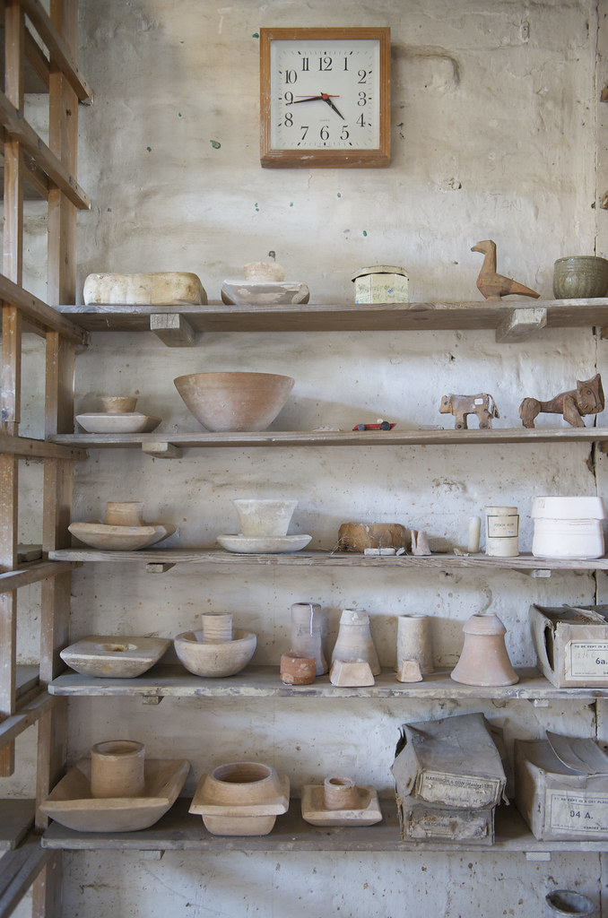 Interior of a working ceramics studio with kiln shelves and equipment